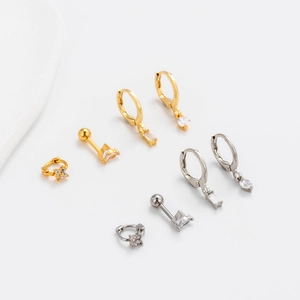 Detailed set of gold and silver piercing earrings with rectangular and clover stones
