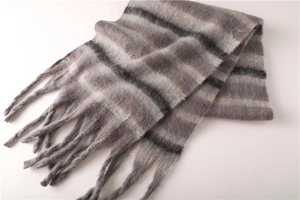 Close-up of grey and black striped scarf showing soft cashmere-like texture and tassels