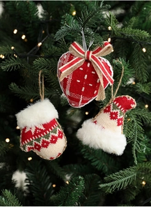 Detail view of knitted Christmas tree ornaments featuring heart, glove, and hat shapes