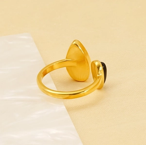 Gros plan d'une bague vintage ajustable plaquée or 18 carats avec pierres noires