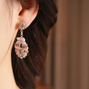 Vintage round diamond and purple gemstone drop earrings in rose gold on model