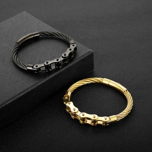 Detail eines Punk-Stahlkabelarmbands mit gold- und schwarzen Motorradketten-Gliedern