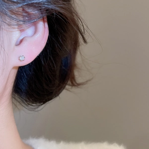 Gros plan d'une boucle d'oreille en zircone avec serti à six griffes sur l'oreille