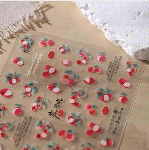 Detailed close-up of lychee themed nail stickers with Chinese calligraphy and glitter