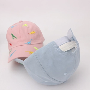 Detail of kids baseball cap featuring cartoon dinosaur embroidery and velcro strap