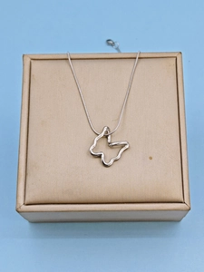 Close-up of hollow butterfly pendant on silver snake chain in a beige gift jewelry box