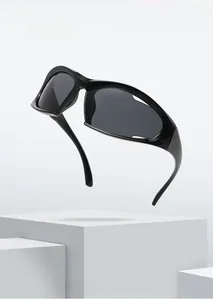 Detail view of black aerodynamic cycling sunglasses with dark grey lenses on minimalist stand