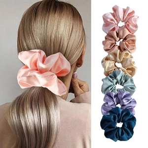 Close-up of silk satin scrunchies in six elegant colors showing smooth fabric texture