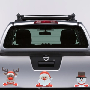 Close-up of reindeer, Santa, and snowman magnetic decals on a silver truck tailgate