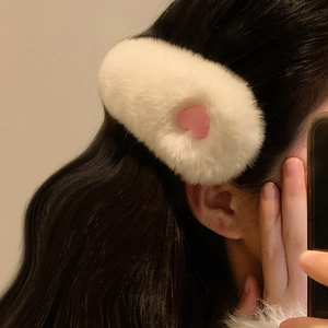 White plush heart hair clip made of Rex rabbit fur on model's long dark hair