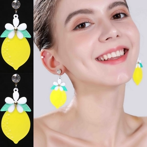 Vibrant yellow acrylic lemon slice earrings with floral detail and crystal stud on model