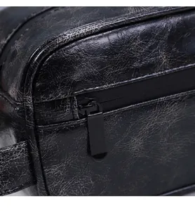 Detail eines hochwertigen Metallreißverschlusses auf schwarzer Leder-Kulturtasche