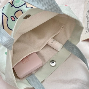 Detail view of canvas bag interior with magnetic clasp, inner pocket and corduroy fabric