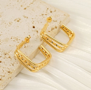 Detail of gold geometric square earrings with triple layered lines and twisted metal texture