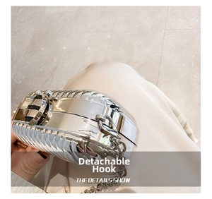 Macro detail of silver acrylic clutch bag with vertical pleats and metal chain link hook