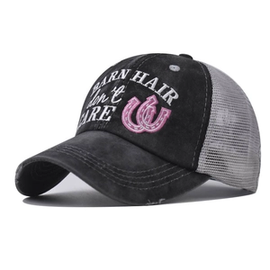 Close-up of vintage washed mesh baseball cap with embroidered letters and distressed brim