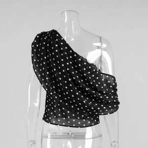 Détail du haut asymétrique à pois blancs en mousseline noire avec volants drapés