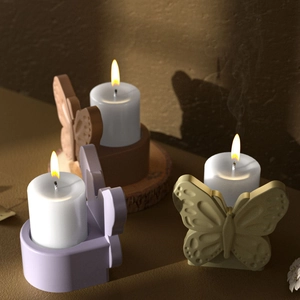 Detail of butterfly-shaped candle holders with wings texture and candle light shadows