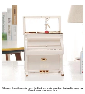 Macro detail of a white piano music box with a rotating ballerina and golden accents