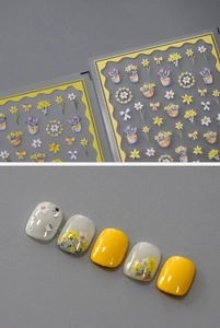 Macro detail of embossed floral nail stickers featuring yellow daffodils and daisy designs