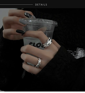 Minimalist silver irregular lava texture rings worn by a model holding a cup