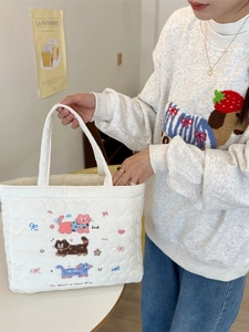 White quilted tote bag with cute cat embroidery and heart stitching shown on model