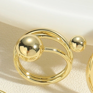 Gros plan sur la bague double anneau dorée avec des sphères métalliques géométriques