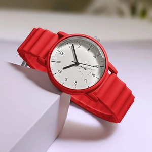 Detail view of red wave silicone strap and minimalist white dial on quartz student watch