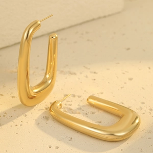 Polished 18K gold-plated stainless steel U-shaped chunky hoop earrings on stone background