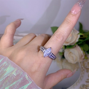 Detailed close-up of marquise-cut zircon ring with pavé diamonds on a model's hand