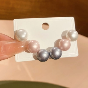 Close-up of 6-piece pearl stud earring set in white, pink, and blue-grey colors
