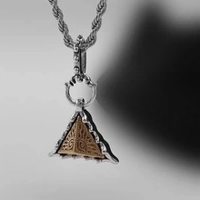 Macro shot of silver twist chain with vintage punk evil eye triangle pendant detail
