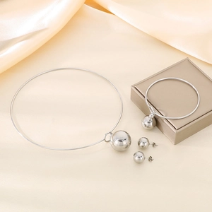 Detailed view of silver stainless steel jewelry set with hollow sphere charms on silk