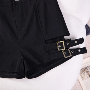 Dettaglio degli shorts neri a vita alta con doppie fibbie in metallo e tagli laterali