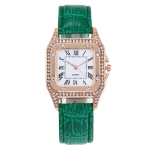 Detail of rose gold square watch case with white crystals and green leather strap