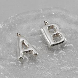 Detail of silver puffy bubble letters A and B with reflective metallic surface finish