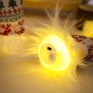 Detail of the warm glowing LED light and plastic battery switch on the gnome base
