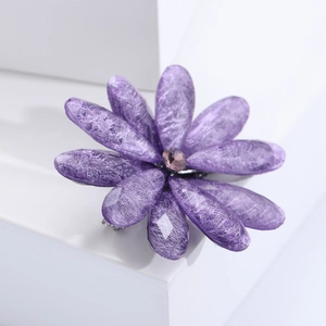 Detailed macro view of purple acrylic flower brooch with resin petals and crystal center