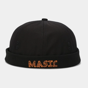 Detail of black Miki Hat showing orange MAGIC embroidery and metal ventilation eyelets