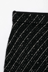 Close-up of black knit tweed fabric with white diagonal dotted pattern texture