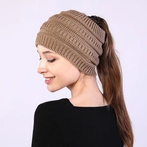 Detail view of khaki knit ponytail beanie with open top design for women's winter styling