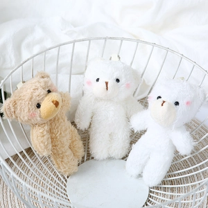Detailed close-up of mini plush teddy bears with blush cheeks in a white wire basket
