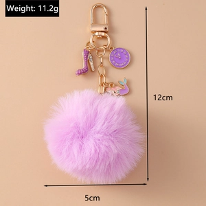 Detail of purple faux rabbit fur keychain with clock, mermaid tail, and high heel charms