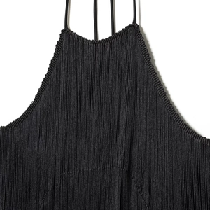Detail of the black velvet halter neck dress featuring dense long fringe tassels and thin straps