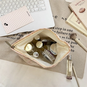 Detail of light pink quilted makeup bag with 3D flower embroidery and silver zipper