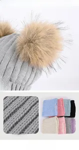 Detailed view of kids winter knit hat with dual pom-poms and warm fleece lining texture