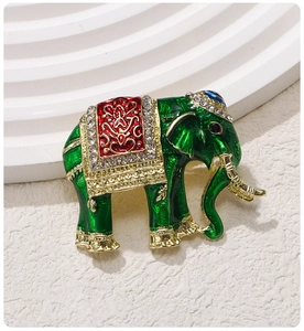 Close-up of elephant brooch with green enamel, red saddle and sparkling crystals