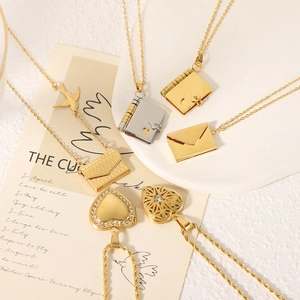 Minimalist gold and silver book pendant necklaces set on decorative card and plate