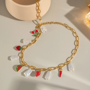 Détail d'un collier en perles dorées avec des pendentifs colorés en émail de fruits