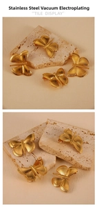 Detail showing butterfly earrings in 18K gold plated stainless steel texture